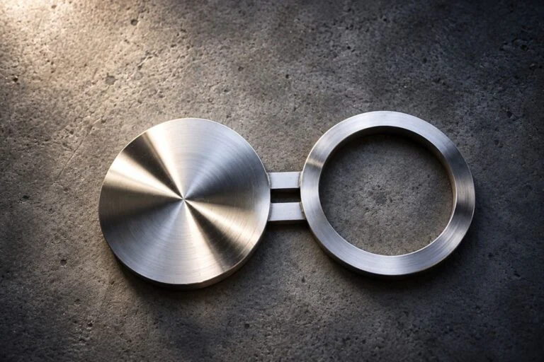 Brida de gafas con disco macizo y anillo espaciador abierto unidos por un puente
