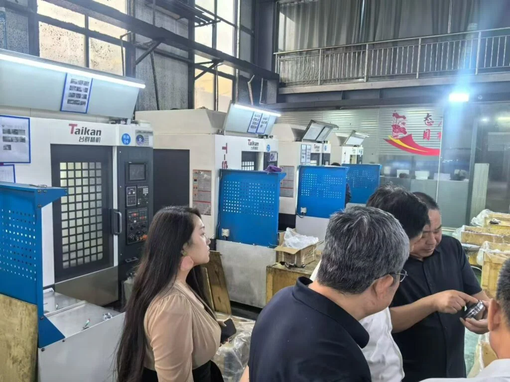 Visiteurs discutant des machines dans l’atelier JINYI
